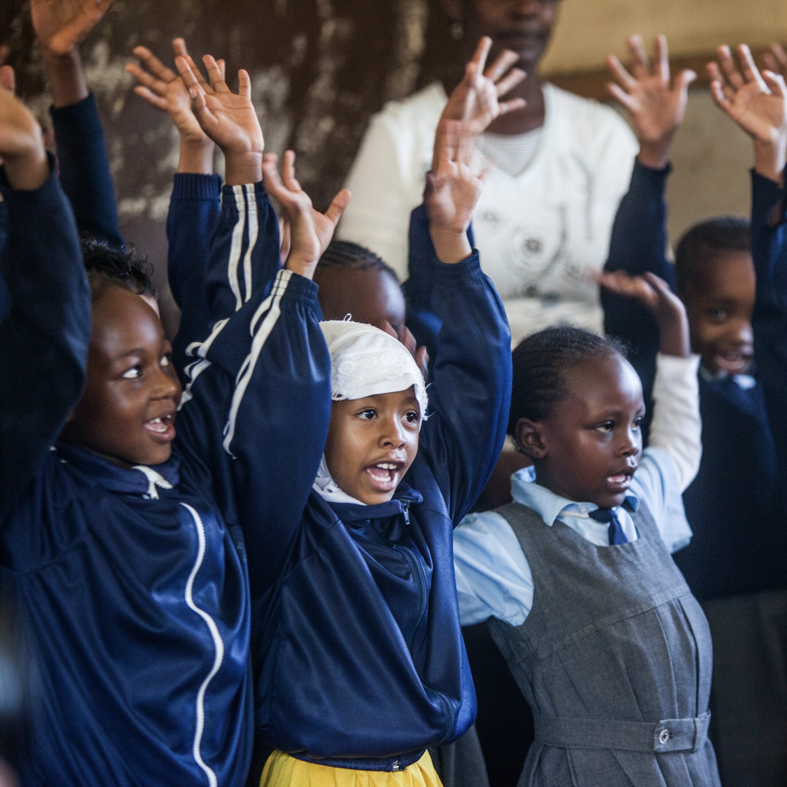 Volunteer teacher helping school kids at their desks